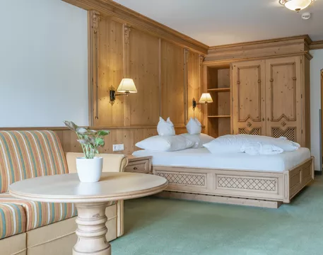 Hotel Kerschdorfer Zillertal Juniorsuite Zillertal Sitzecke und Doppelbett