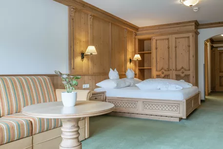 Hotel Kerschdorfer Zillertal Juniorsuite Zillertal Sitzecke und Doppelbett